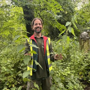 Ken Greenway holding large nettles on wild food and nature walk at Tower Hamlets